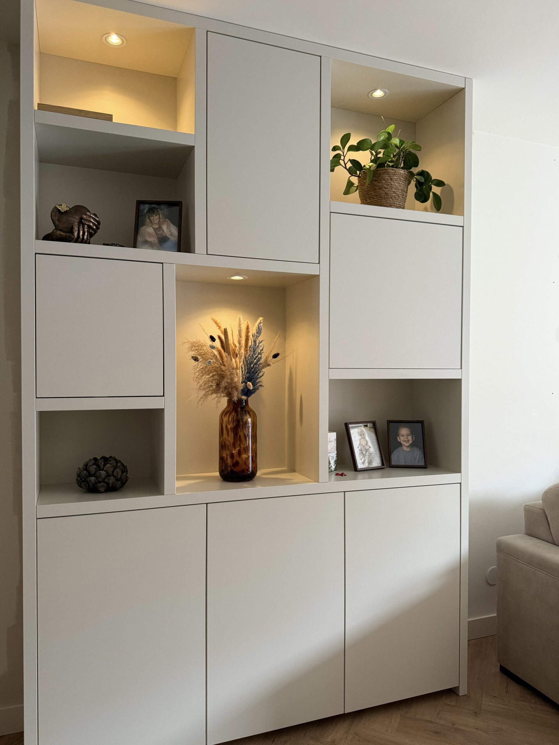 Maatwerk kast met open vakken en ingebouwde verlichting, uitgevoerd in mat wit met decoratieve elementen, ontworpen door Dutch Interieur Design in Alblasserdam.